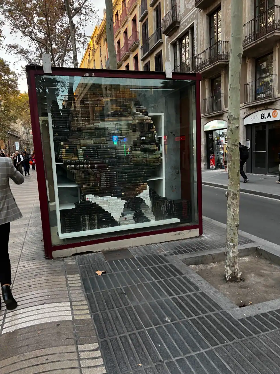 A bookseller's window packed with secondhand books stacked and facing outward, seen at an angle.