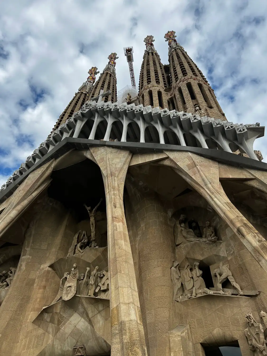 A sculpted stone facade against bright cloud, figures carved in rows across it.