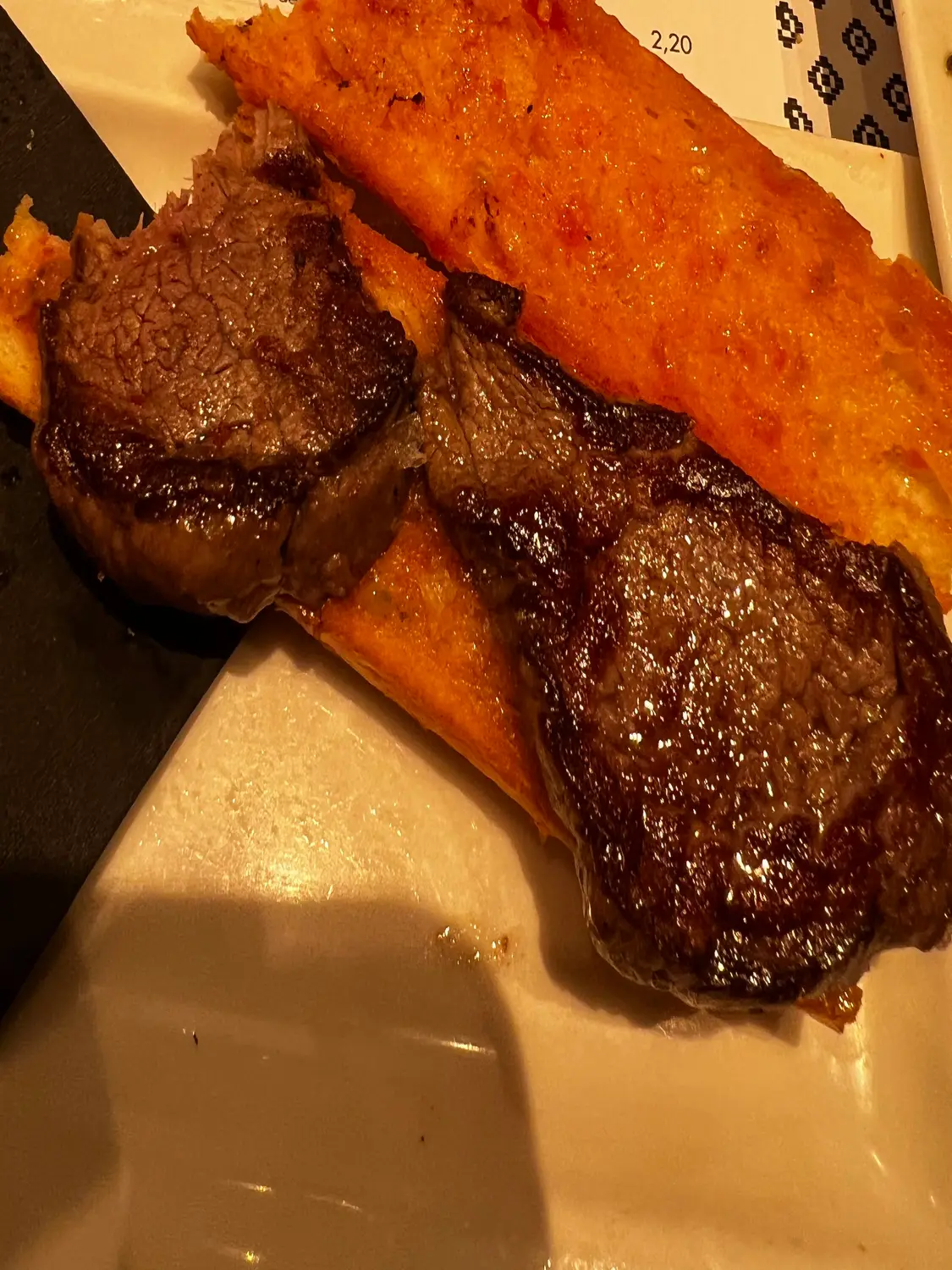 Sliced meat and a fried pastry on a plate.
