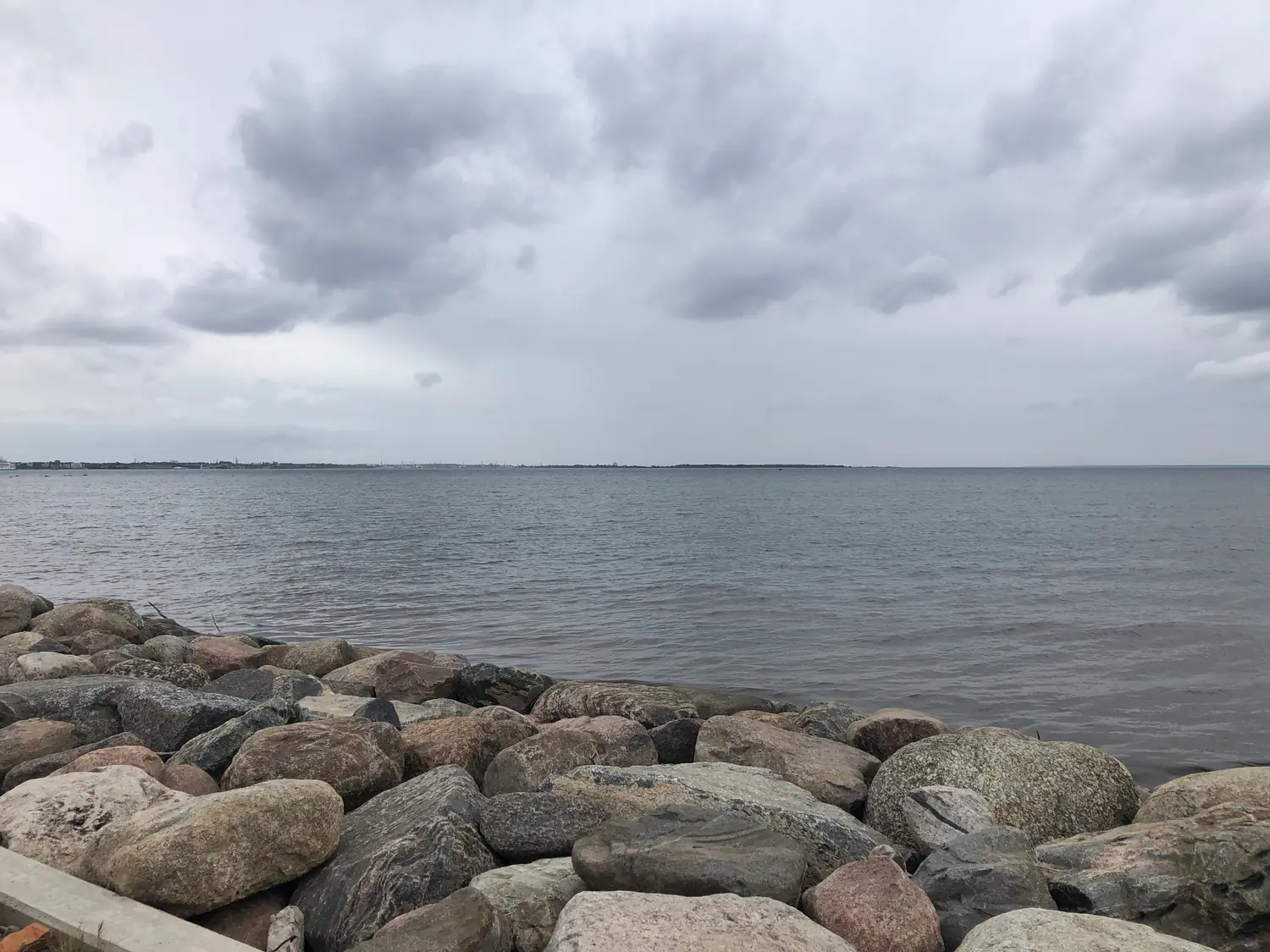 A shore of rounded stones meeting the water.