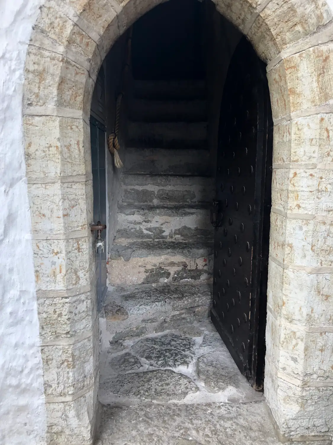 An arch of stone steps and a dark wooden door.