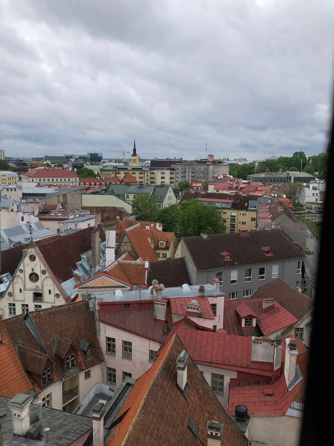 Roofs of red tiles and a tower seen from above.