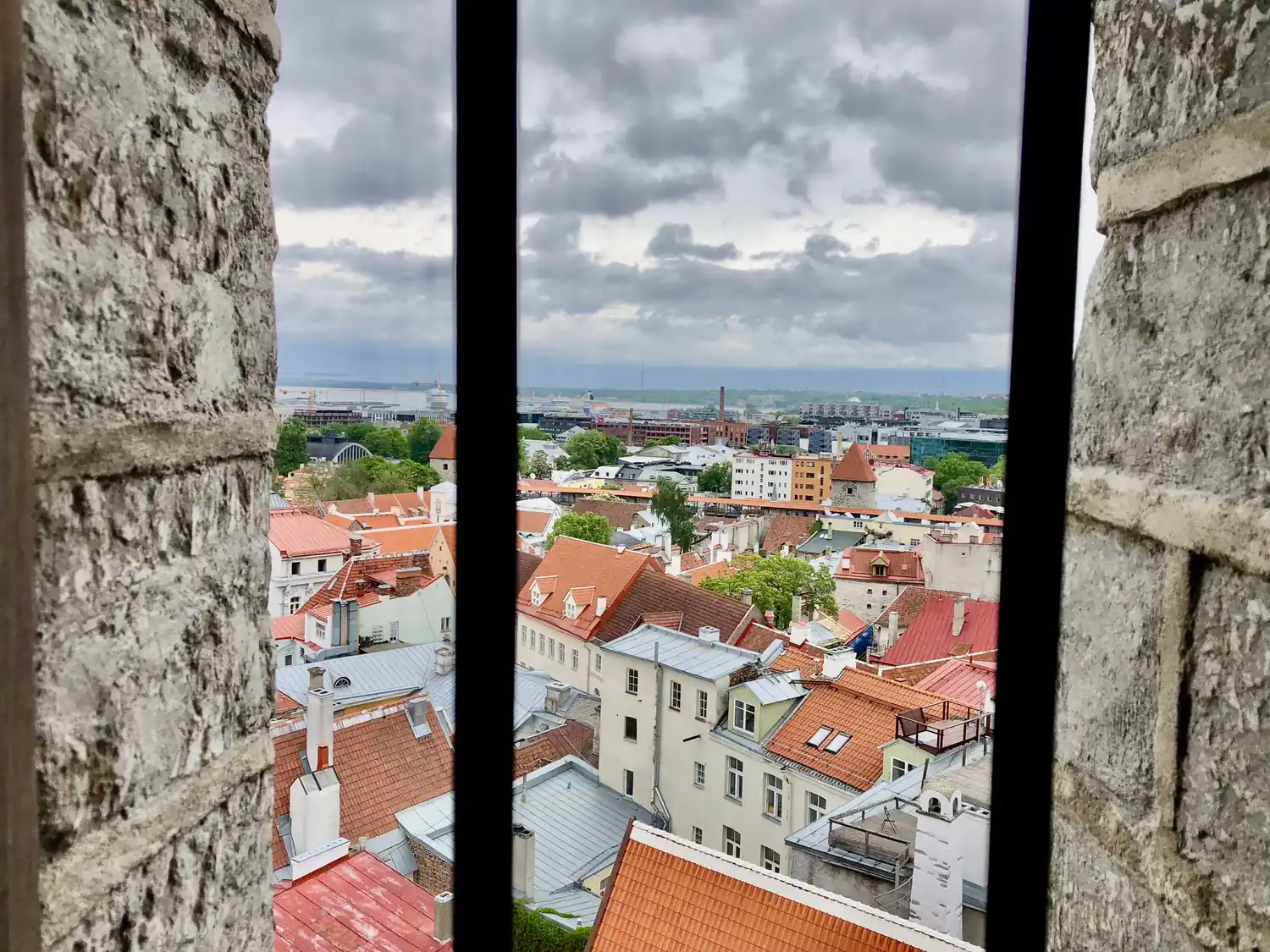 Roofs and a shore seen between two window mullions.