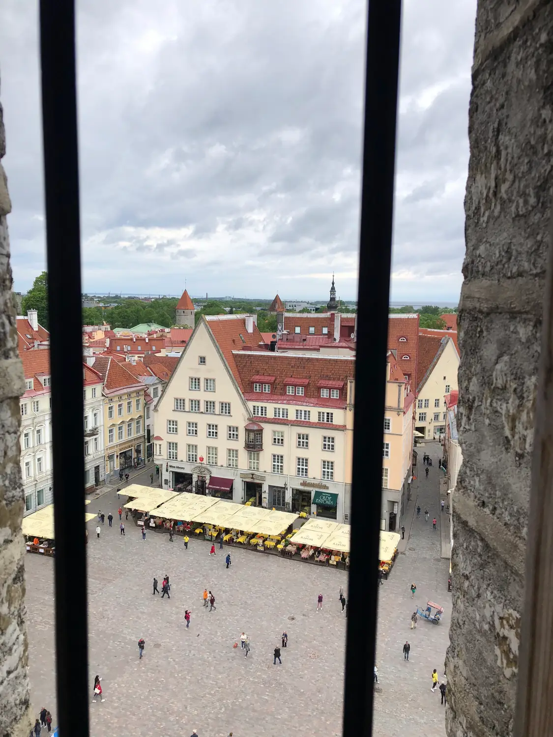 A square and streets seen through a window from a tower.
