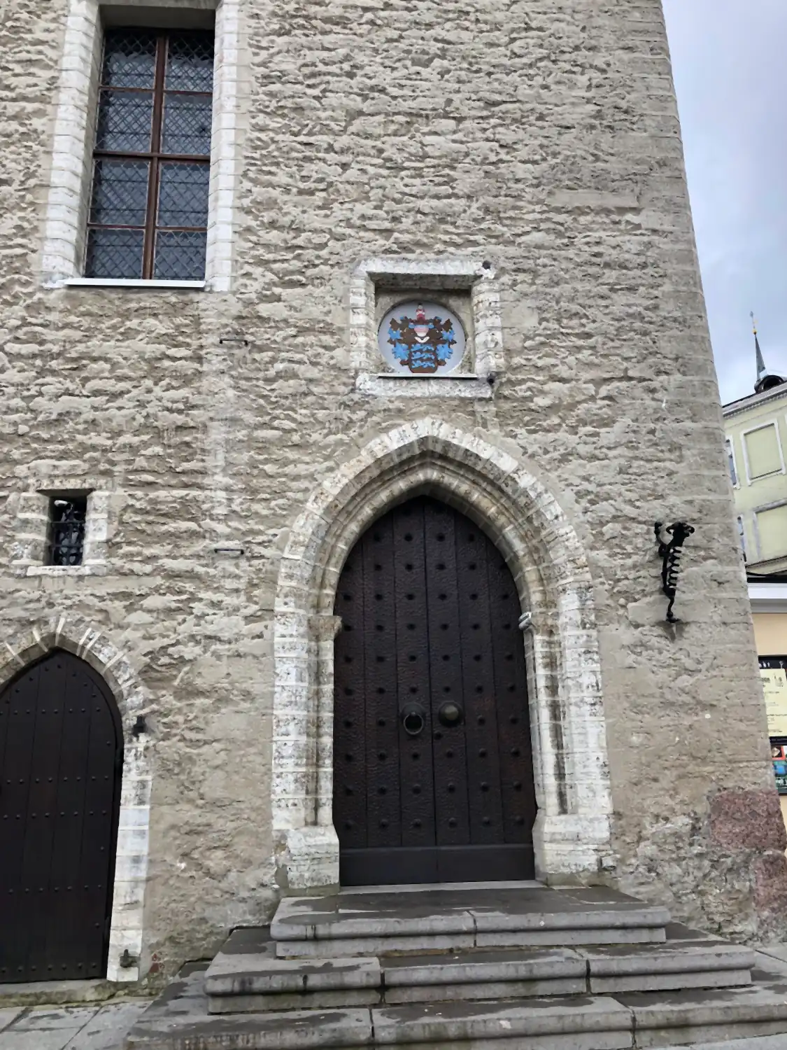 A stone building with a carved doorway and a small crest above it.