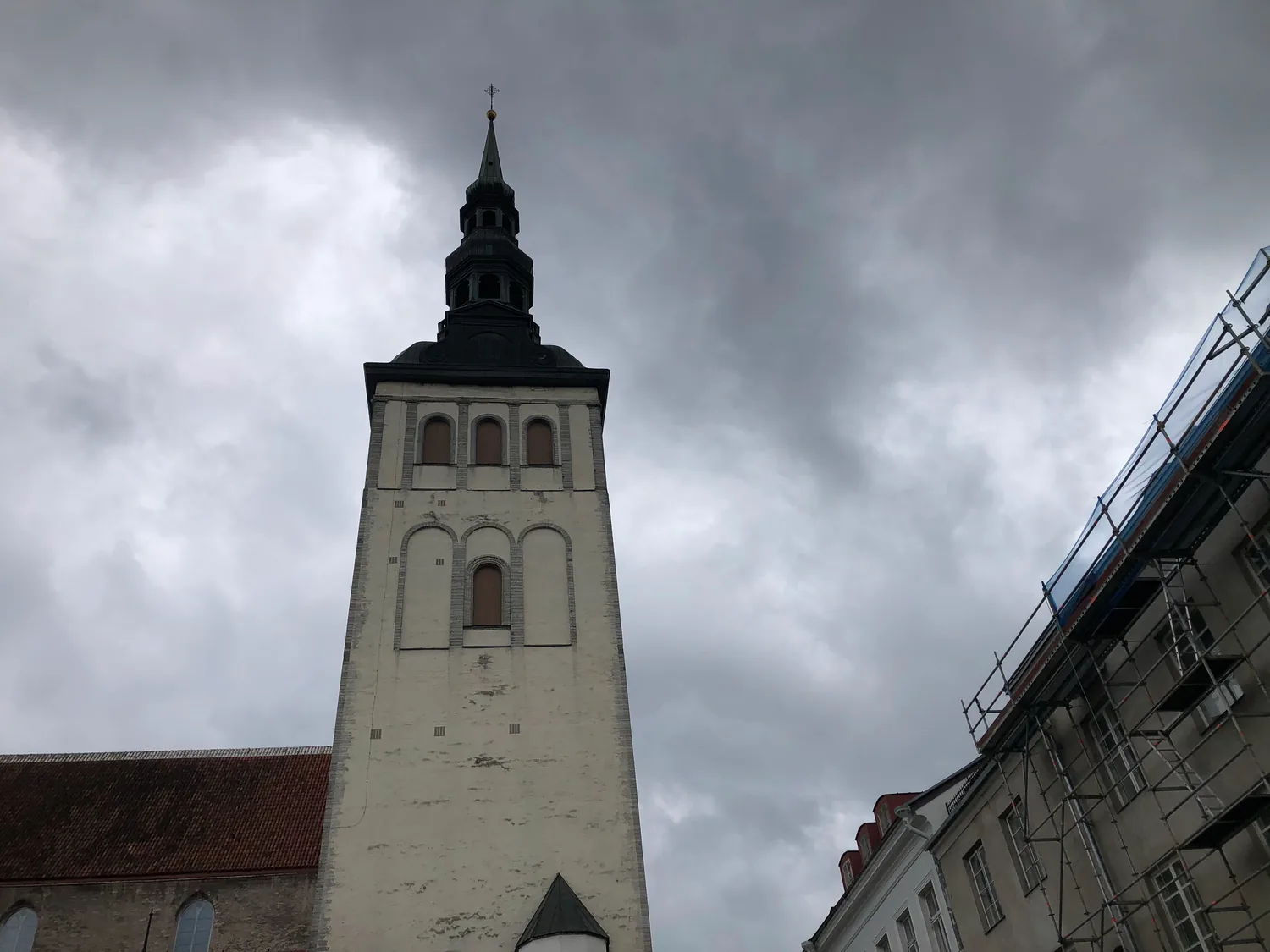 A white church tower and its spire against the sky.