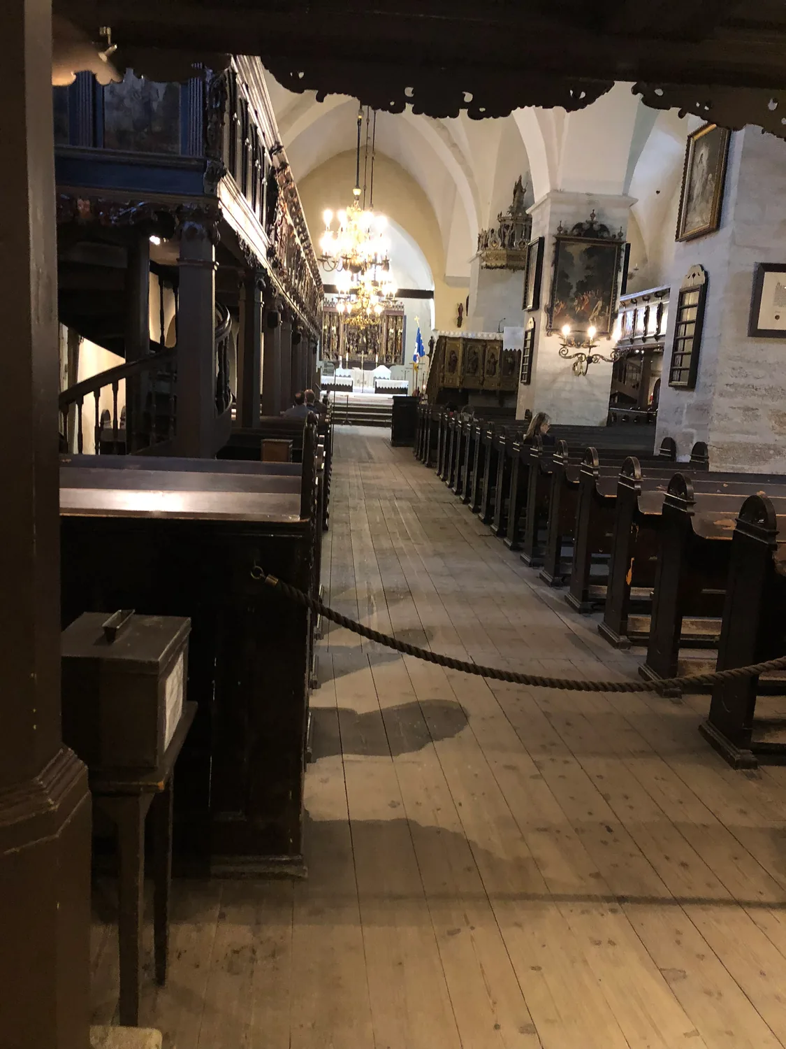 The inside of a church with rows of pews under stone arches.