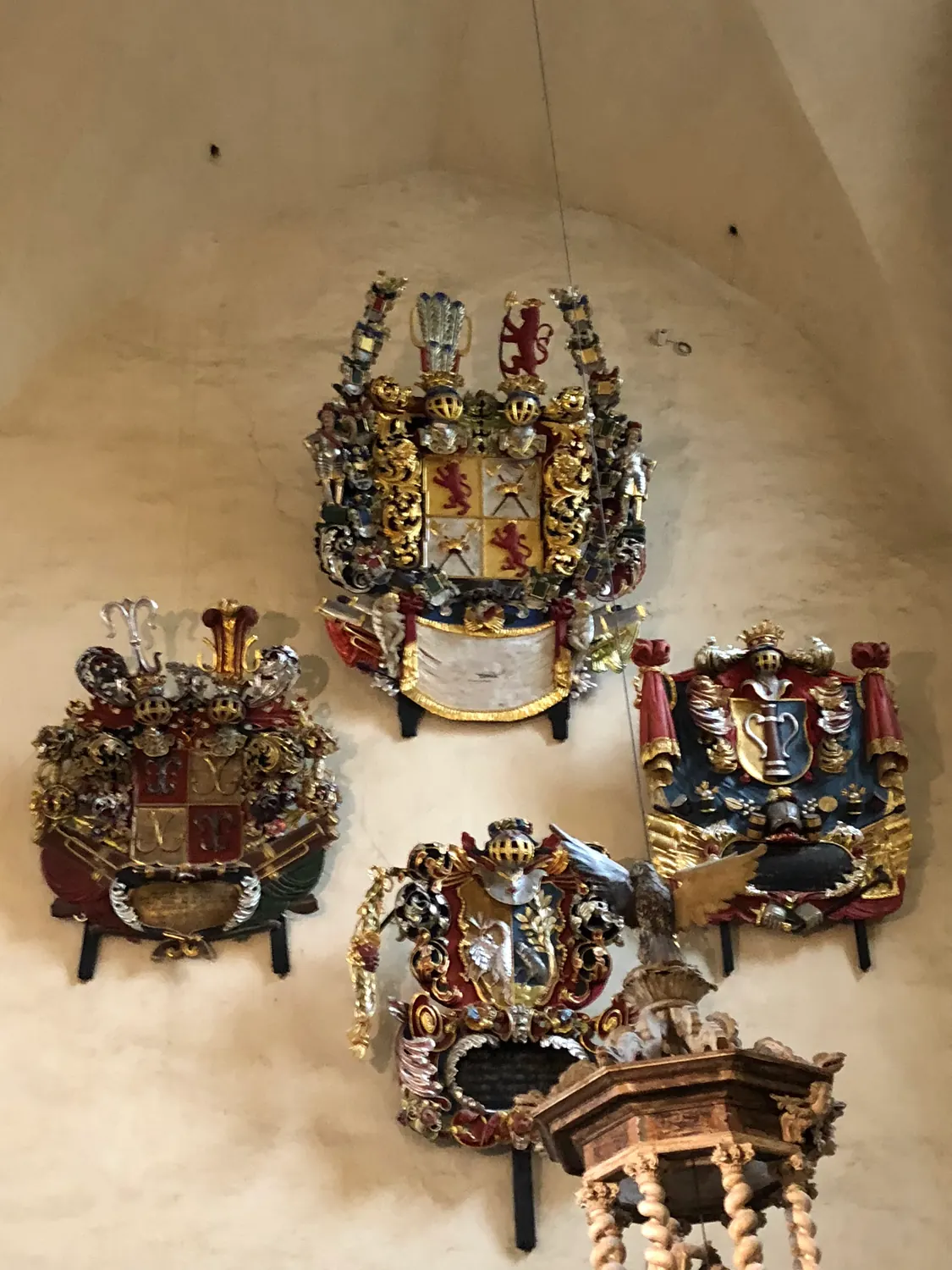 A church wall of ornate metal plaques with a painted panel among them.