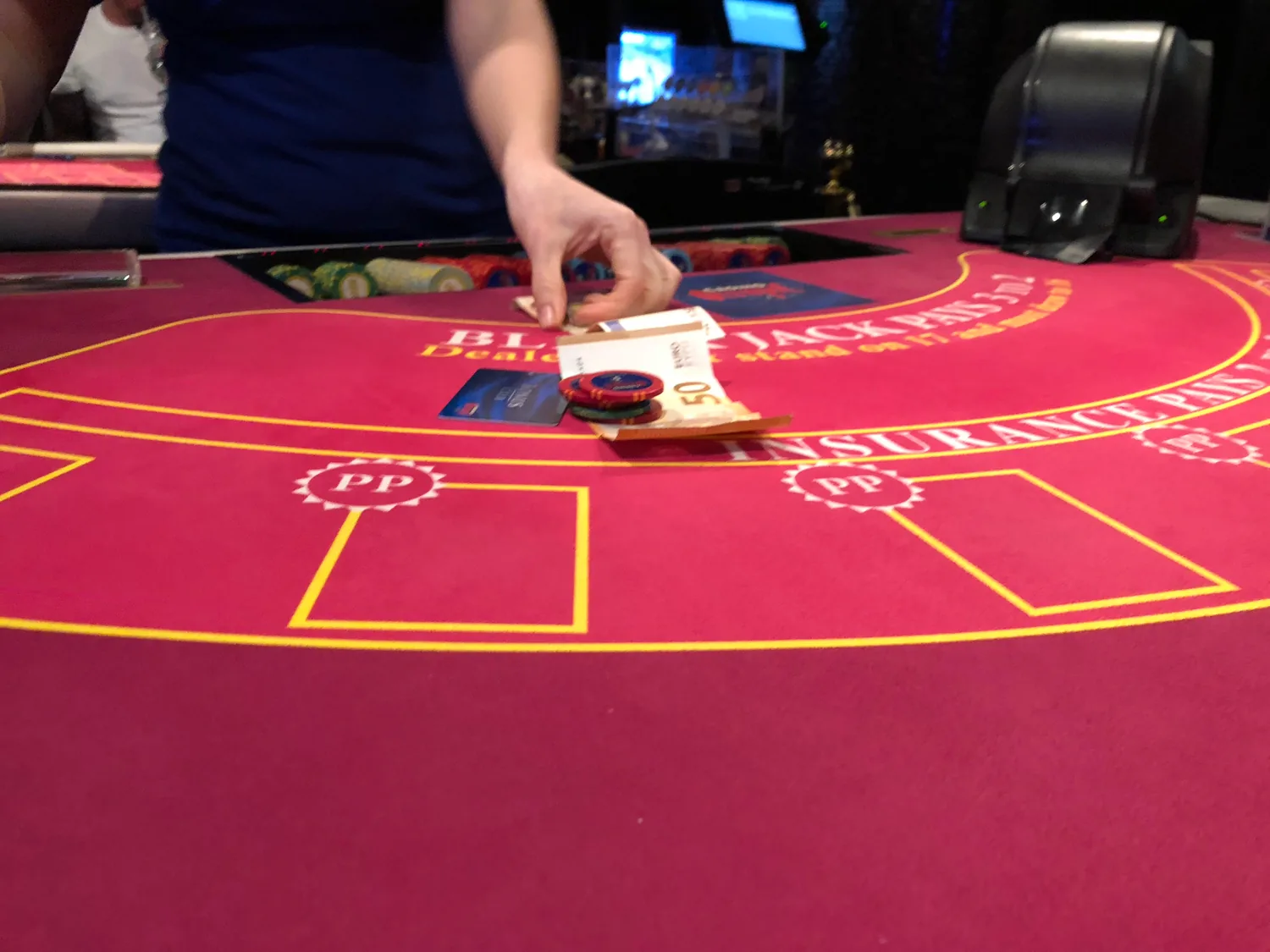 A card table with a dealer's hands, cards and chips.