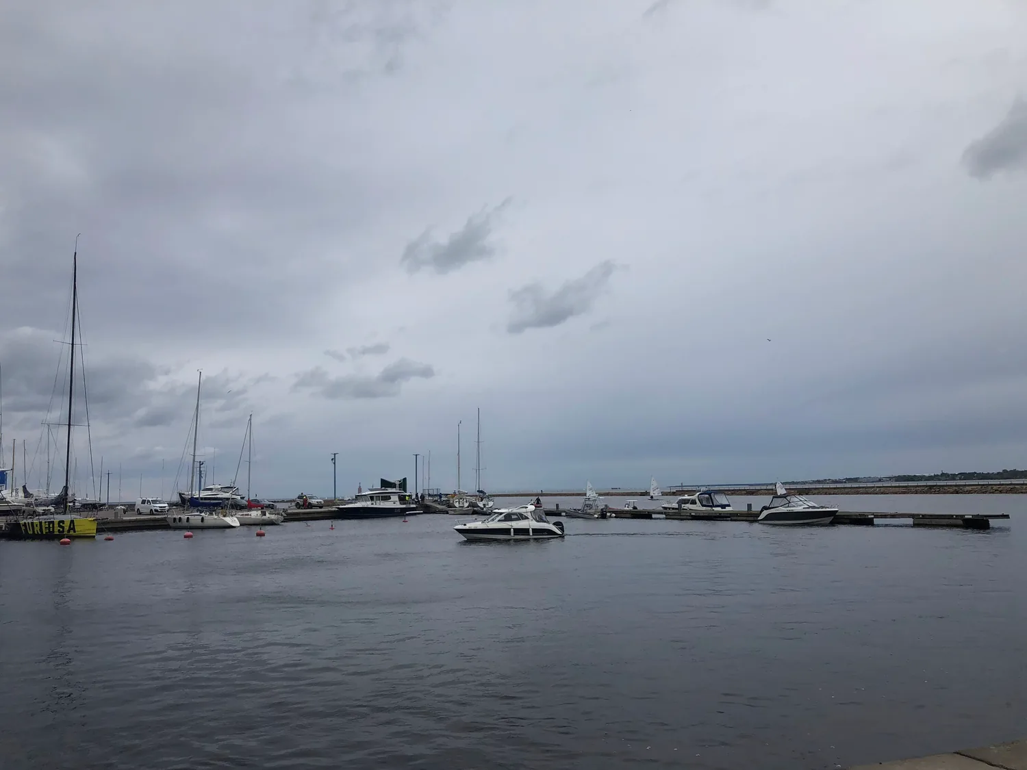 A harbour wall with small boats moored along it.